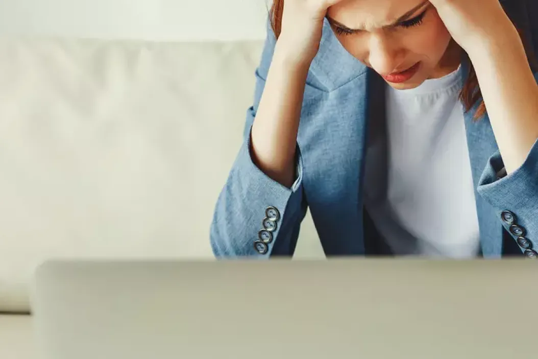 Unzufriedene Arbeitnehmerin vor dem Laptop