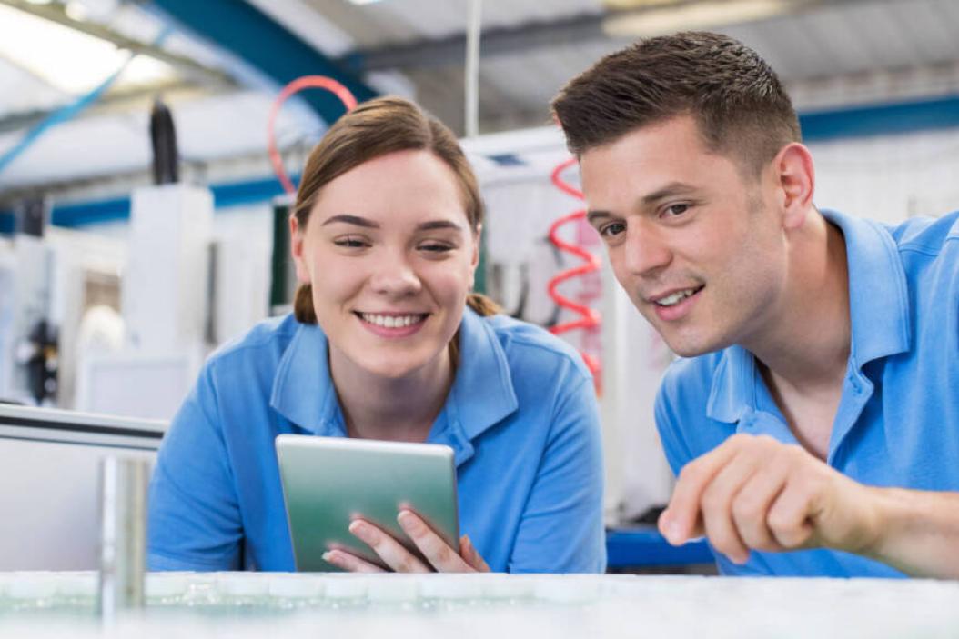 Zwei junge Auszubildende/Trainees in einem Betrieb in der Technik