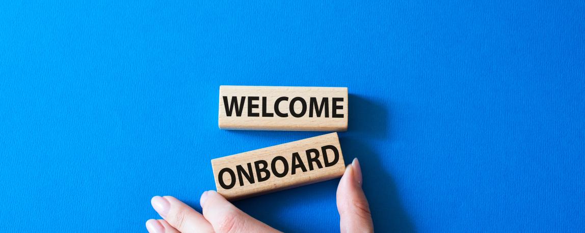 Zwei Holzbausteine, die untereinander gereiht sind und sagen: "Welcome onboard" 