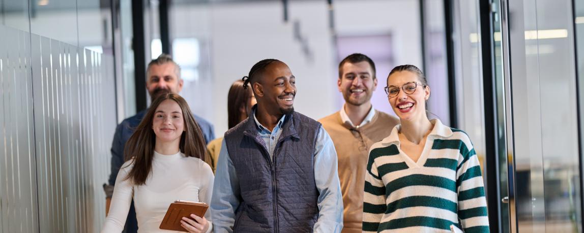 Arbeitskollegen gehen den Office-Korridor lachend runter